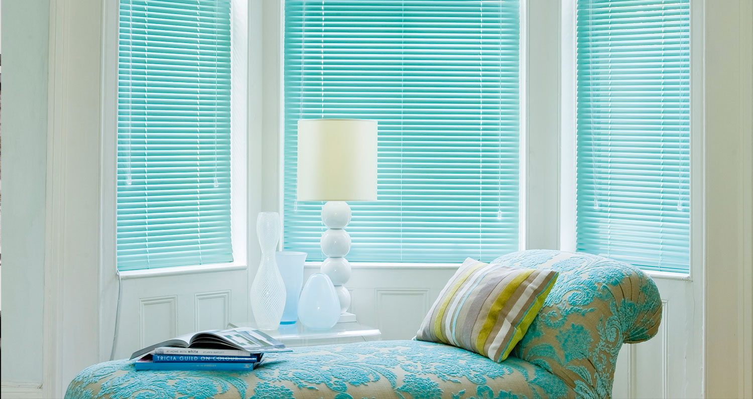 Light blue Venetian horizontal slat blinds in a bedroom